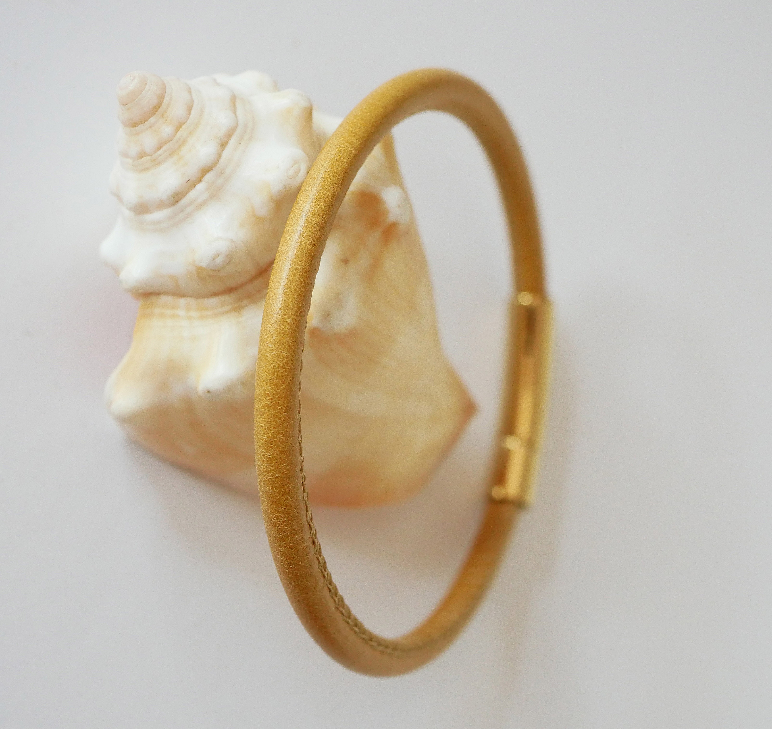 Rundt damearmb&aring;nd i skinn med bajonettl&aring;s i gull