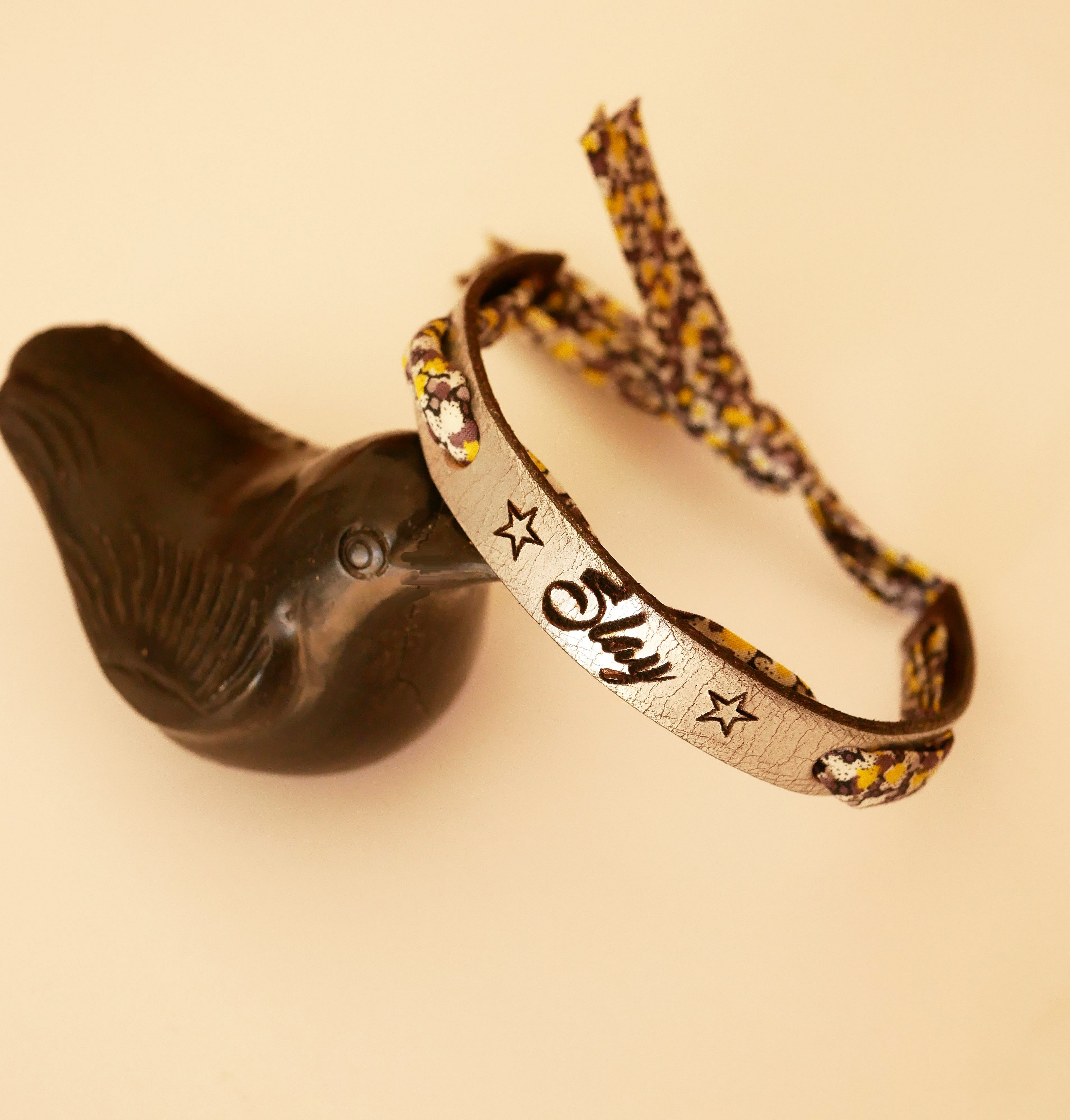 Flor&acirc;me-armb&aring;nd gravert med gule blomster i libertyb&aring;nd p&aring; s&oslash;lvfarget skinn