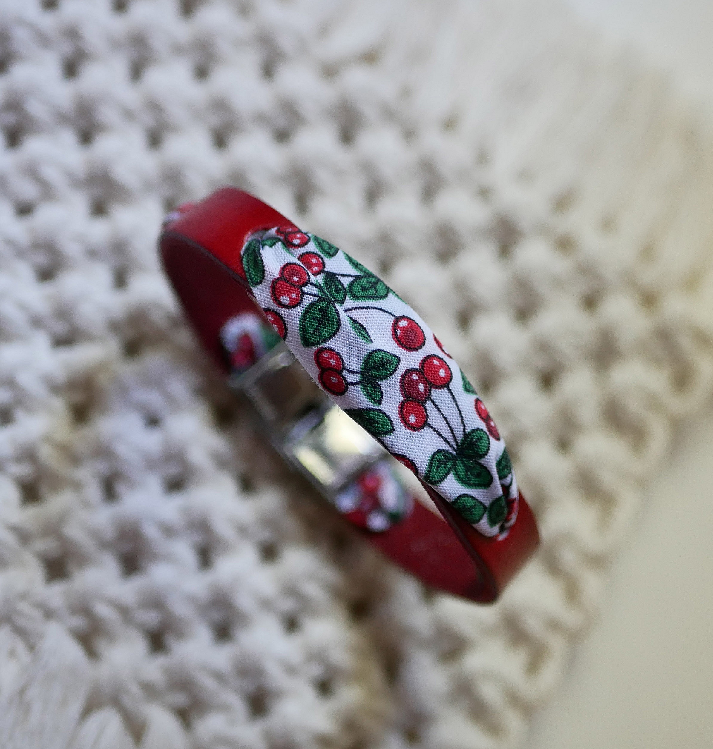 Flor&acirc;me-armb&aring;nd med b&aring;nd av kirseb&aelig;rfrukter p&aring; r&oslash;dt skinn