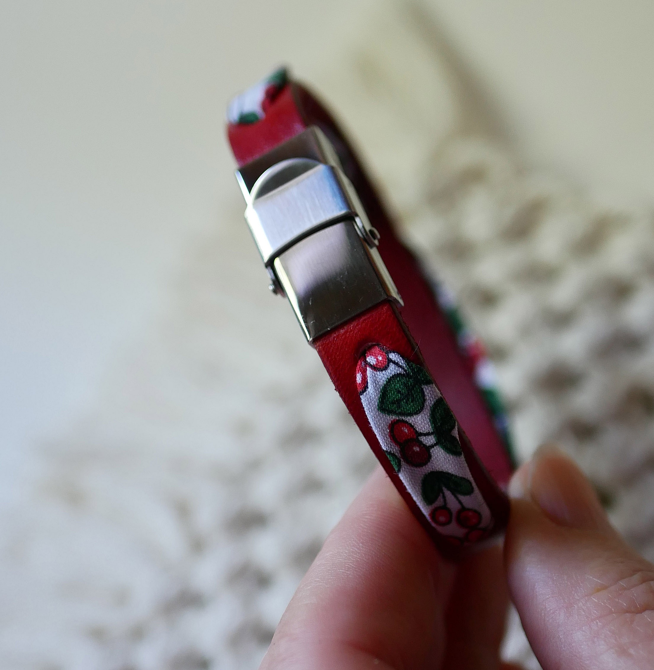 Flor&acirc;me-armb&aring;nd med b&aring;nd av kirseb&aelig;rfrukter p&aring; r&oslash;dt skinn