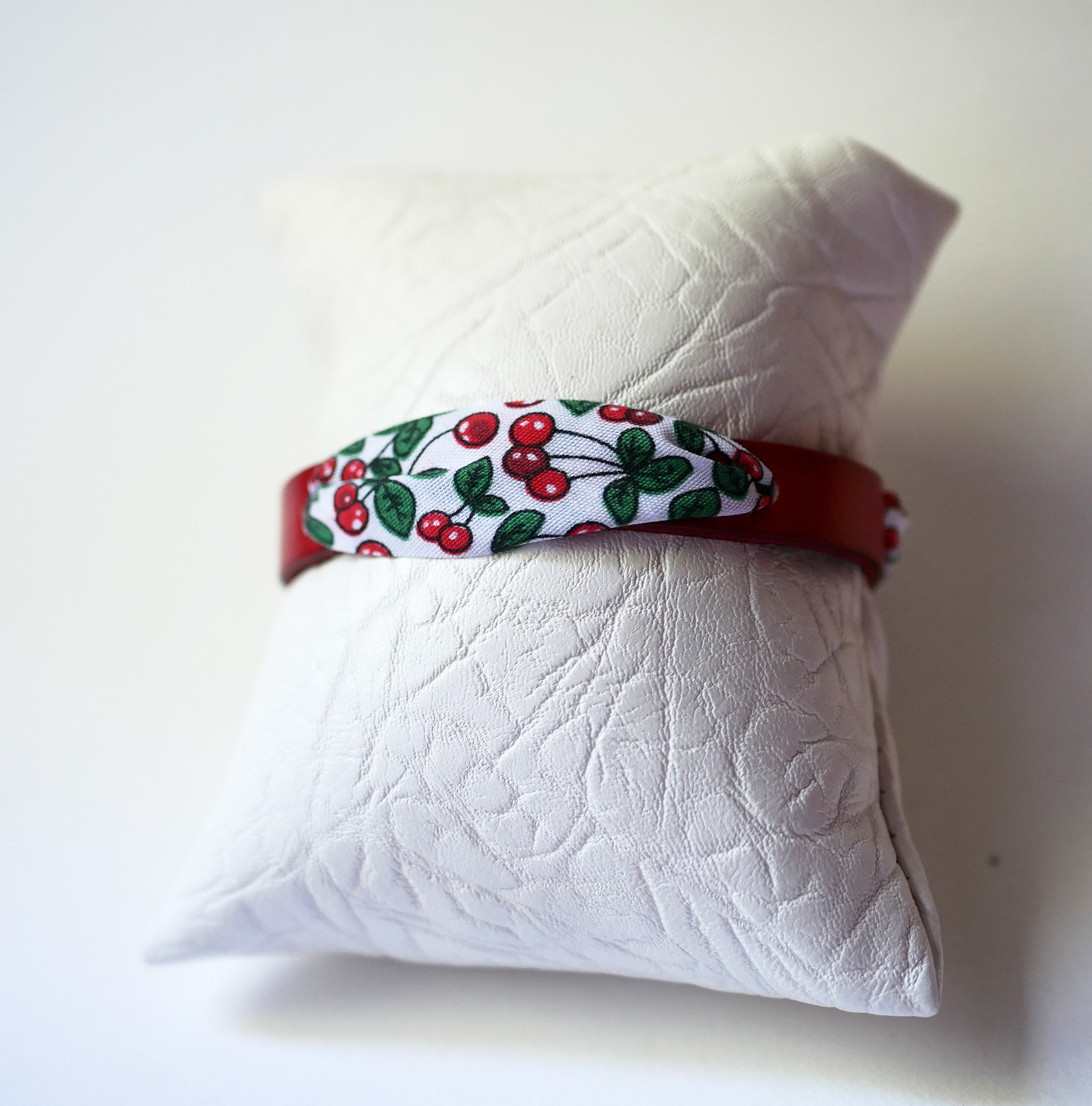 Flor&acirc;me-armb&aring;nd med b&aring;nd av kirseb&aelig;rfrukter p&aring; r&oslash;dt skinn