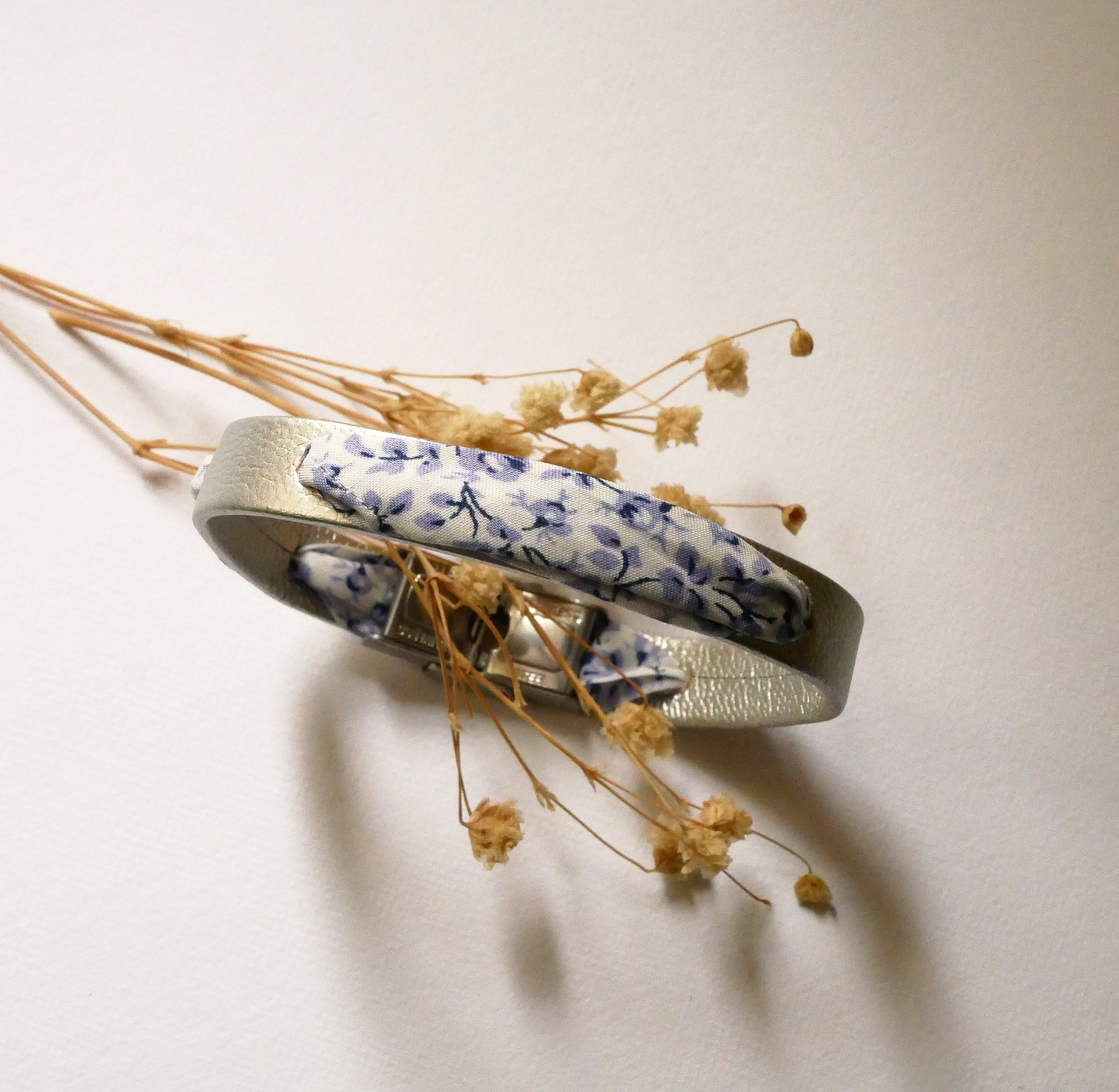 Flor&acirc;me-armb&aring;nd med bl&aring; blomster i libertyb&aring;nd p&aring; s&oslash;lvfarget skinn