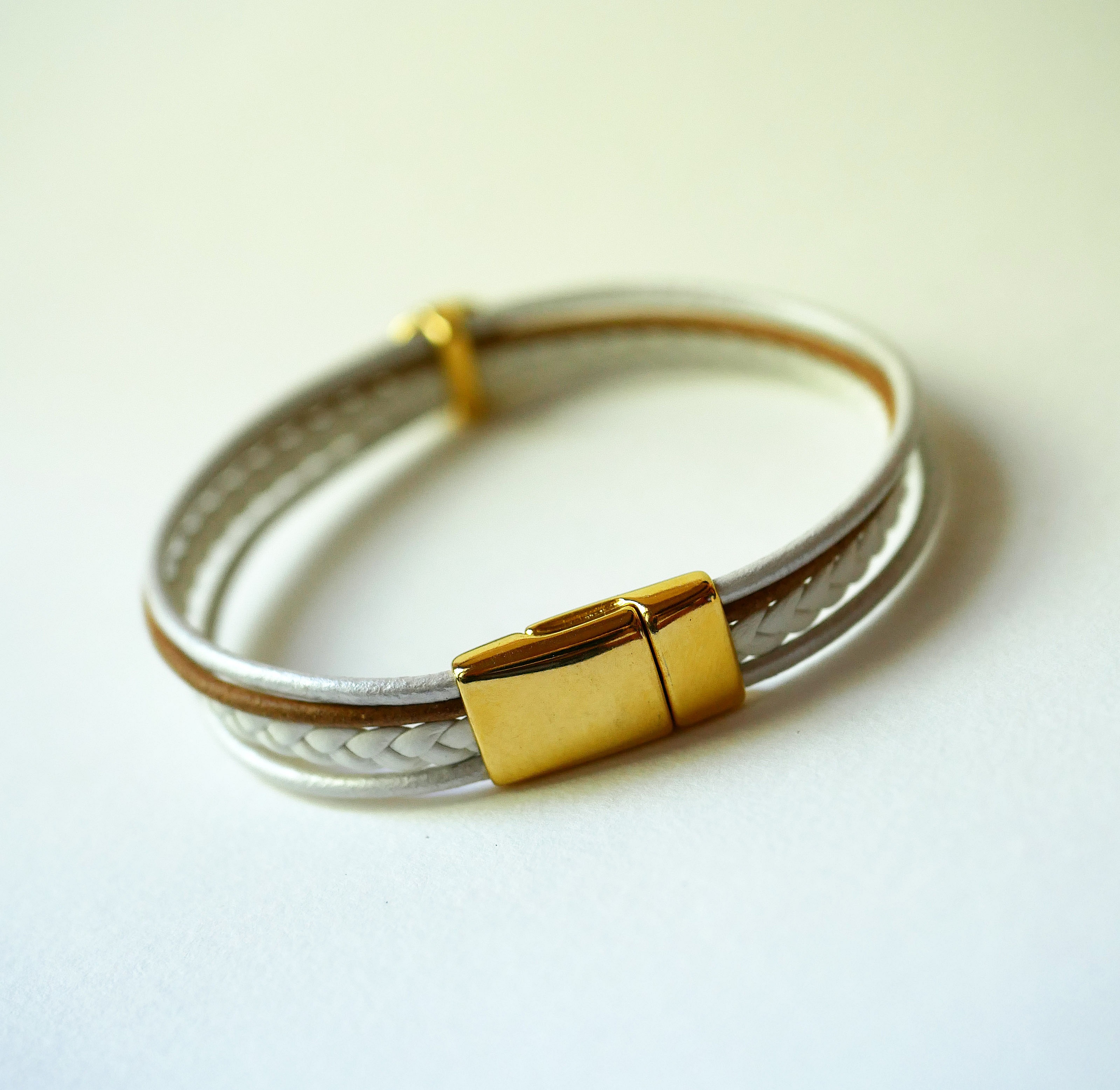 Mansjettarmb&aring;nd i hvitt og gull med cabochon av livets tre