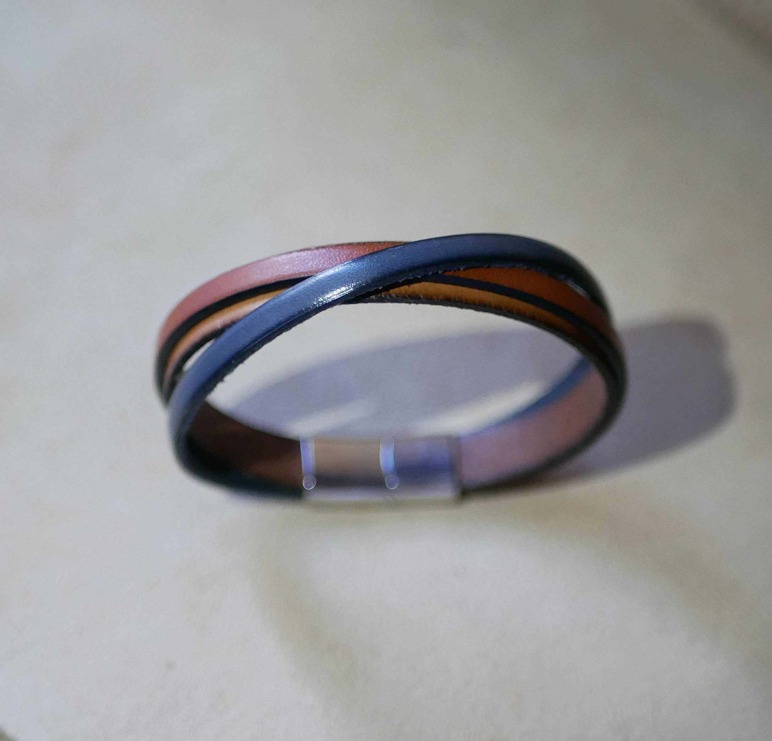 Tofarget mansjettarmb&aring;nd i krysset skinn med inngravert budskap for menn