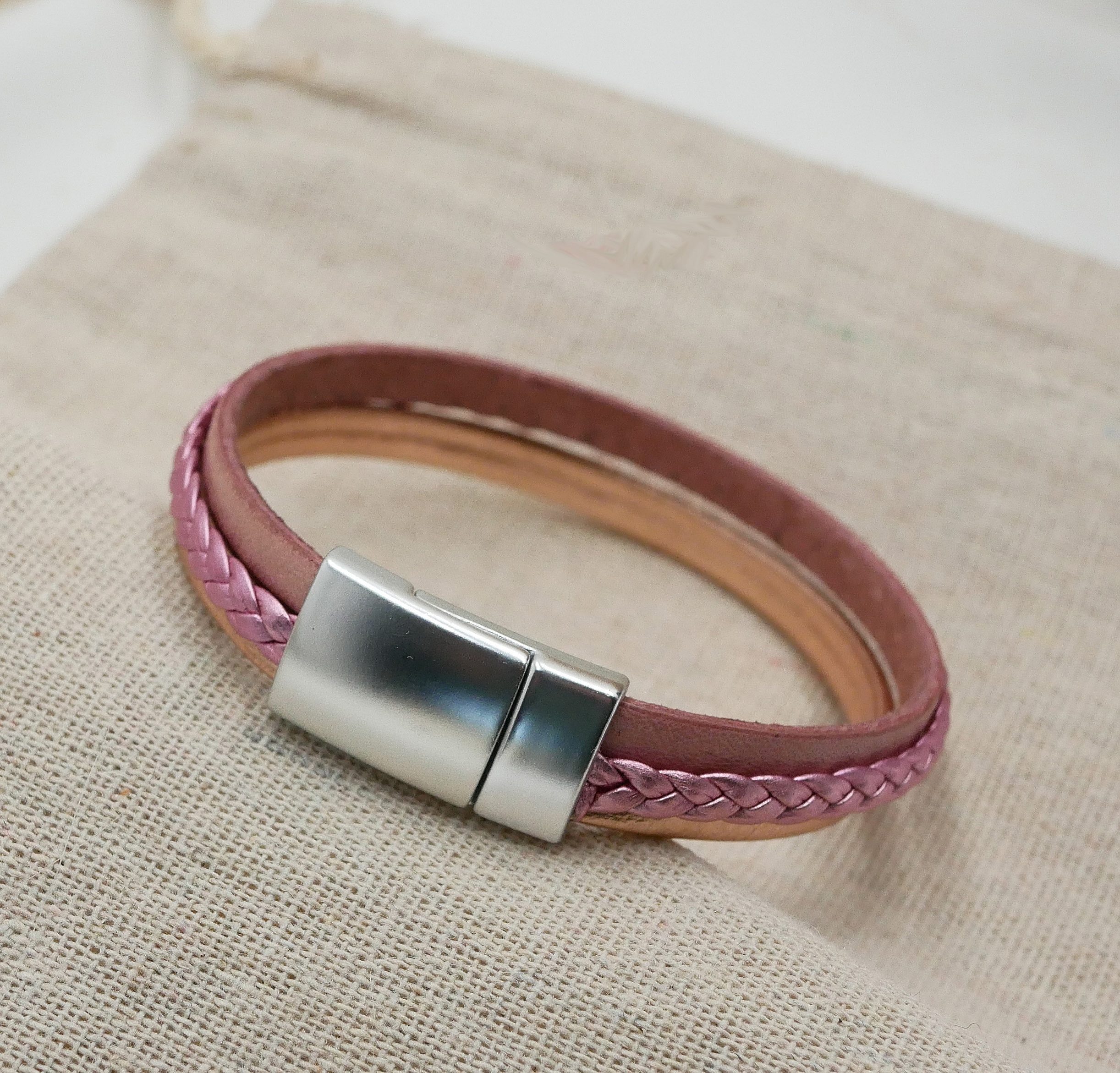 Mansjettarmb&aring;nd i rosa laminert l&aelig;r og ferskenfarget skinn, kan tilpasses etter &oslash;nske