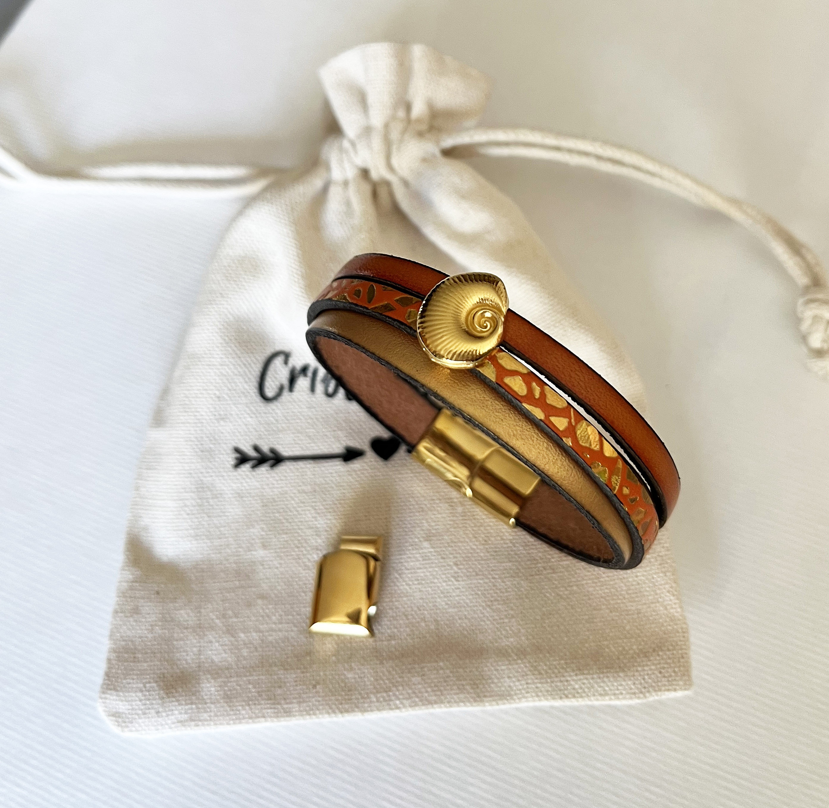 Mansjettarmb&aring;nd i gull for kvinne Gull og oransje skjell