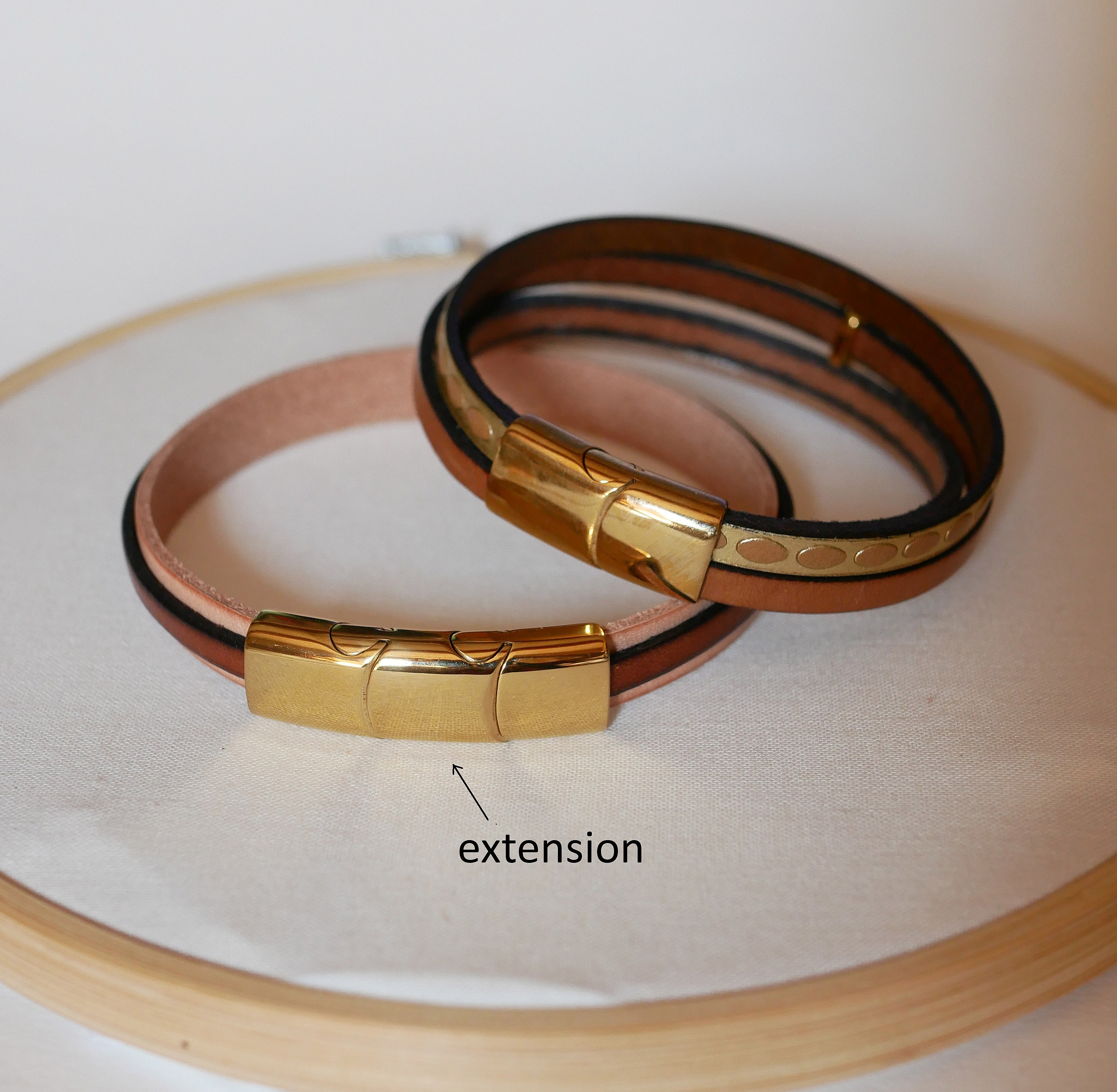 Mansjettarmb&aring;nd i skinn med flere lenker og solstr&aring;le-l&oslash;kke i gull