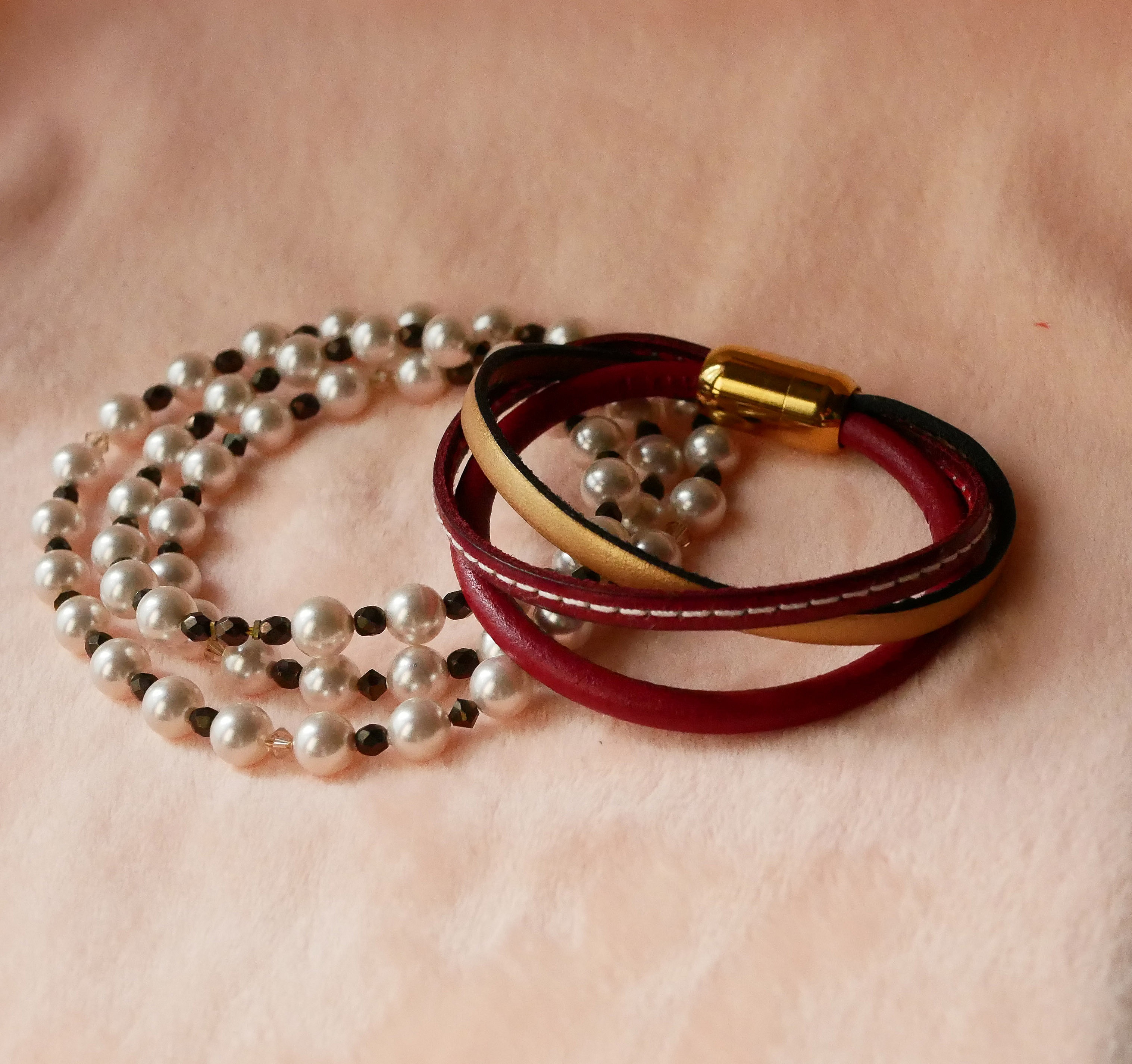 Mansjettarmb&aring;nd i r&oslash;dt og gull i flere skinntyper for kvinner