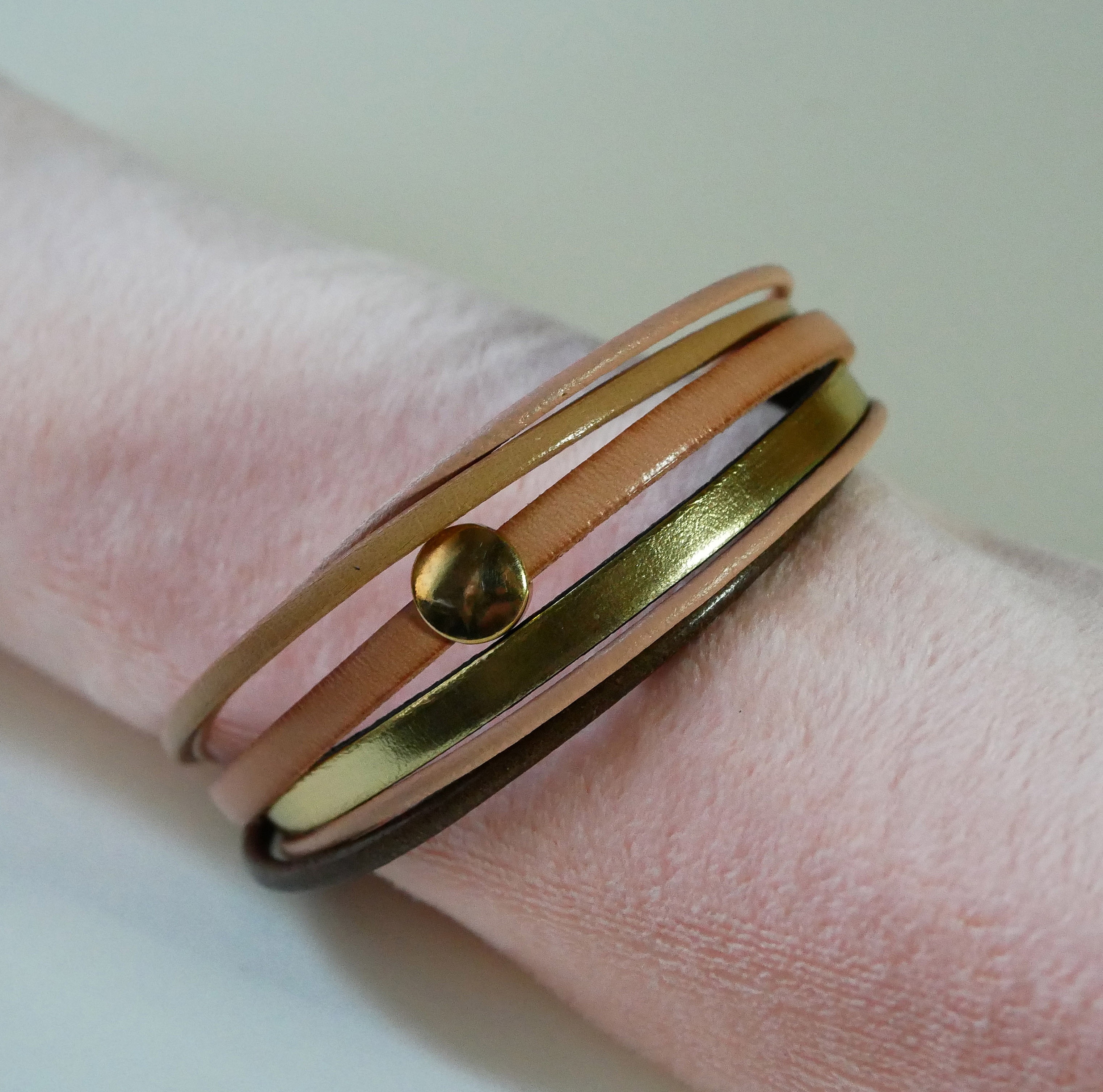 Mansjettarmb&aring;nd i fersken og gull i flere skinntyper for kvinner