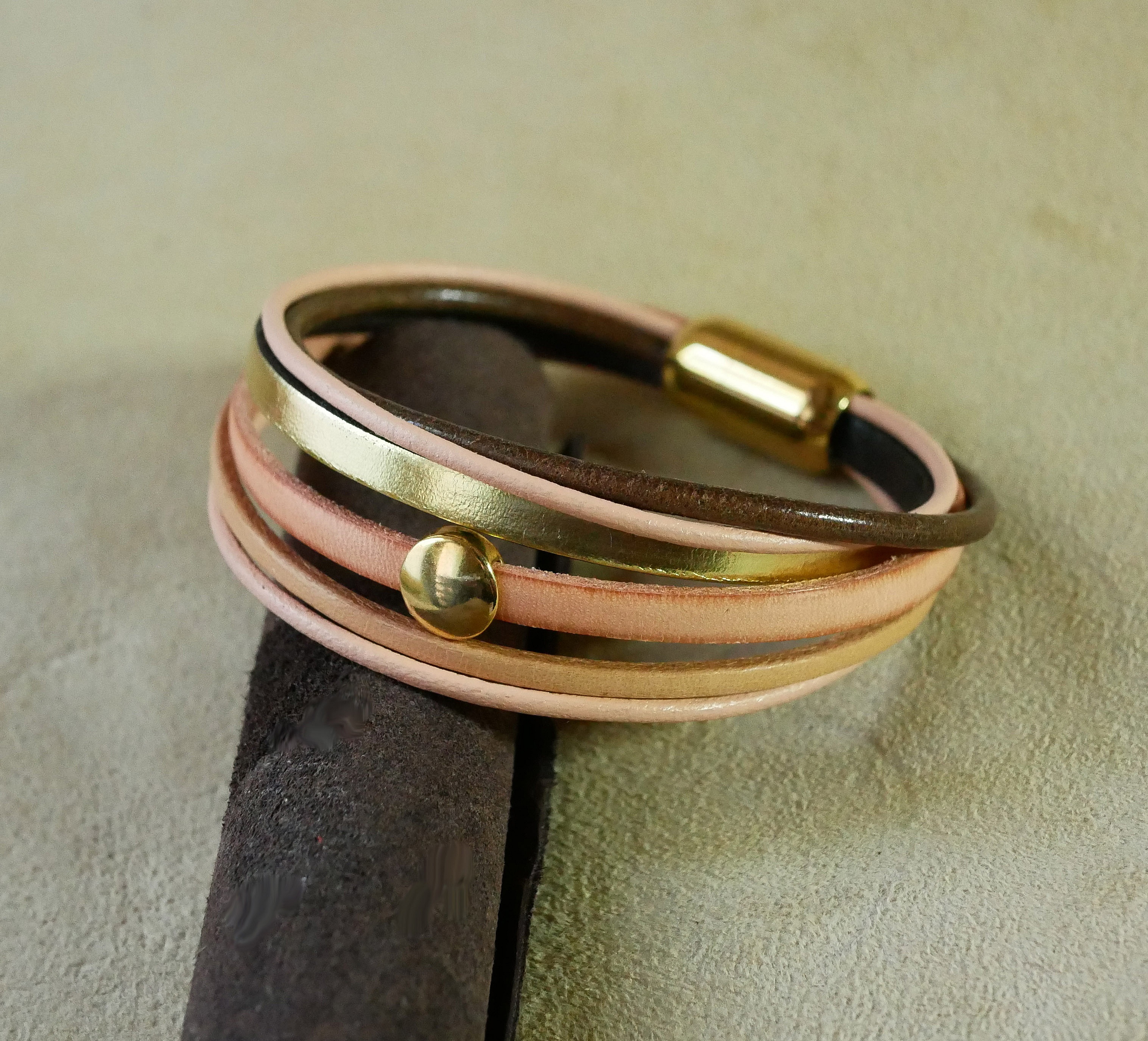 Mansjettarmb&aring;nd i fersken og gull i flere skinntyper for kvinner