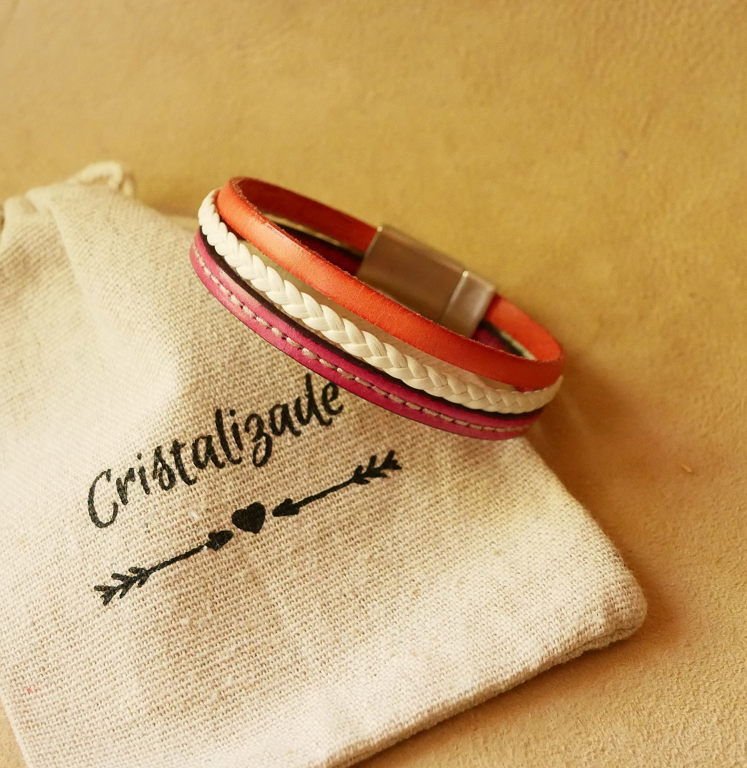 Flettet mansjettarmb&aring;nd i hvitt og korallfarget skinn