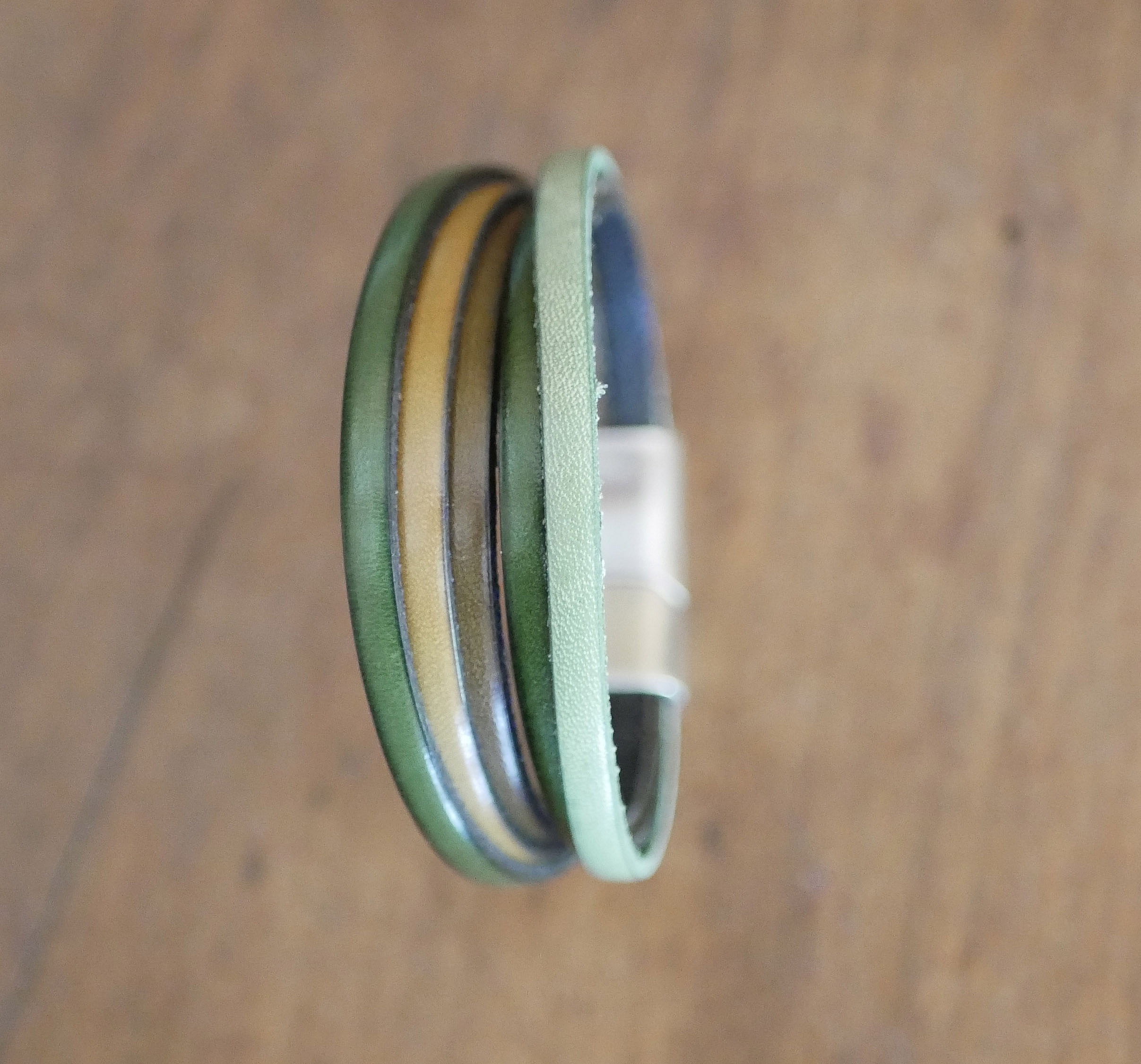 Mansjettarmb&aring;nd i flere skinnfarger i gr&oslash;nne nyanser