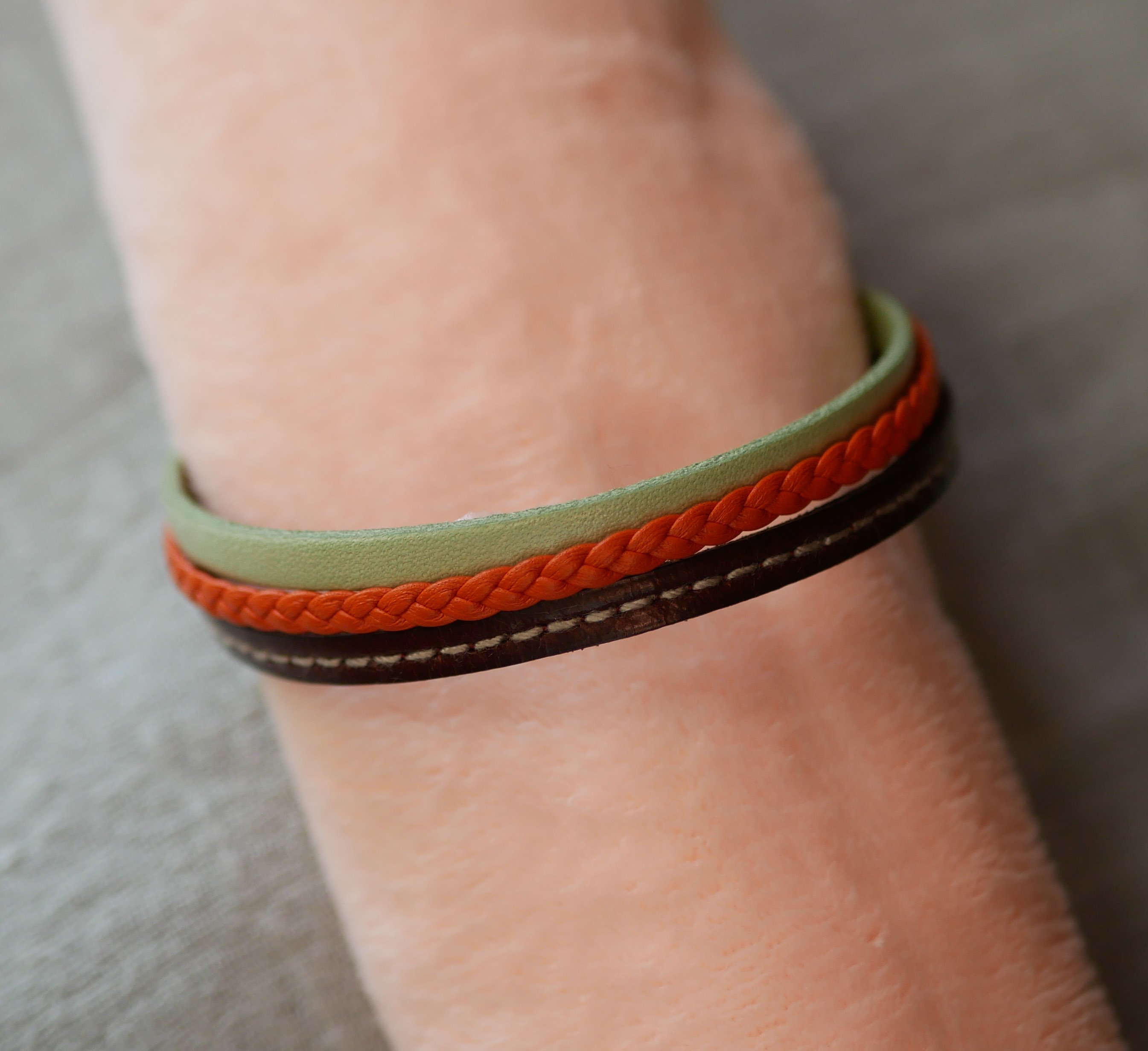 Mansjettarmbånd i flere skinntyper med mandel, oransje flette og Bordeaux-søm