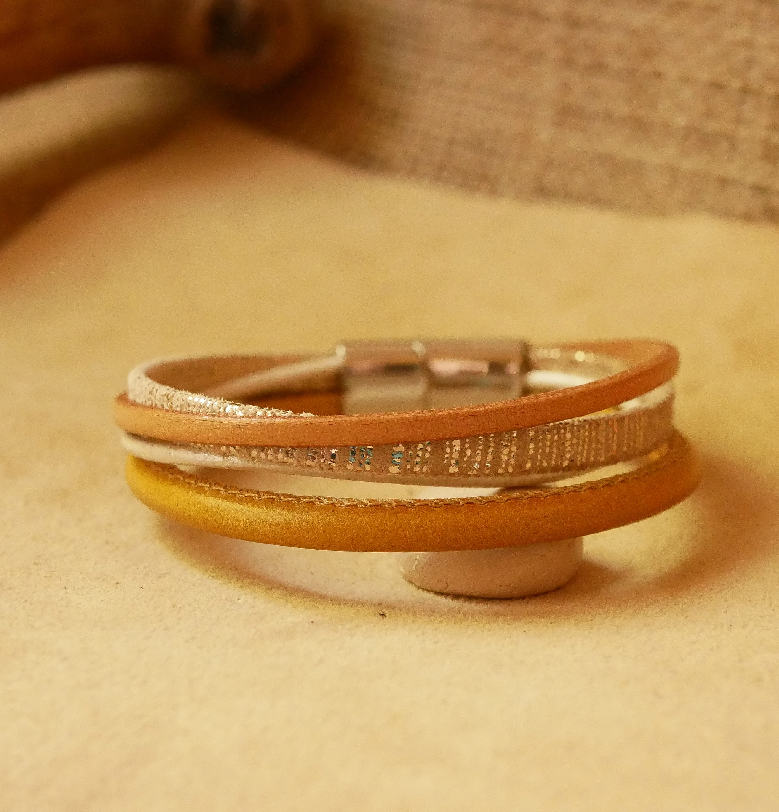 Mansjettarmb&aring;nd i beige og gull i flere skinntyper