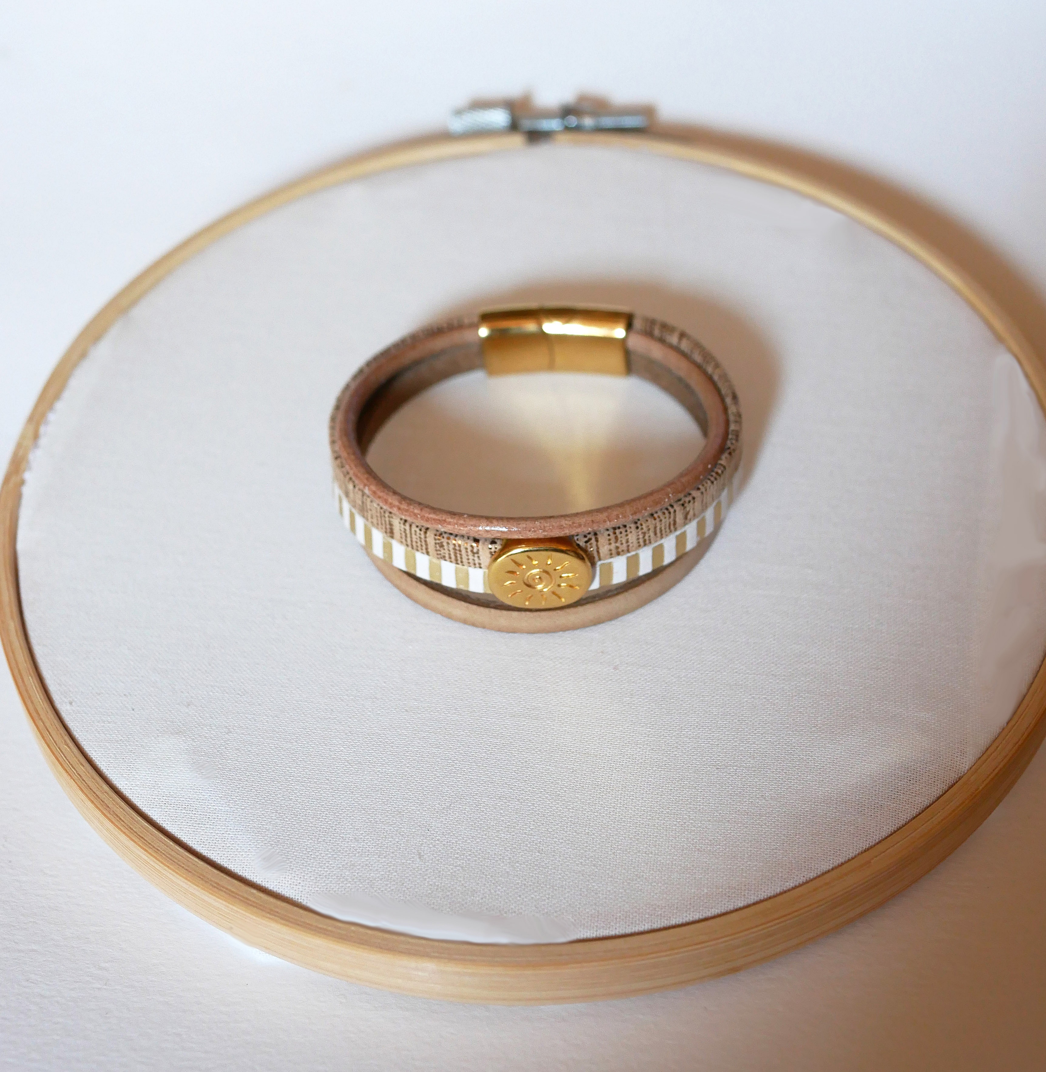 Mansjettarmb&aring;nd i skinn med flere lenker og solstr&aring;le-l&oslash;kke i gull