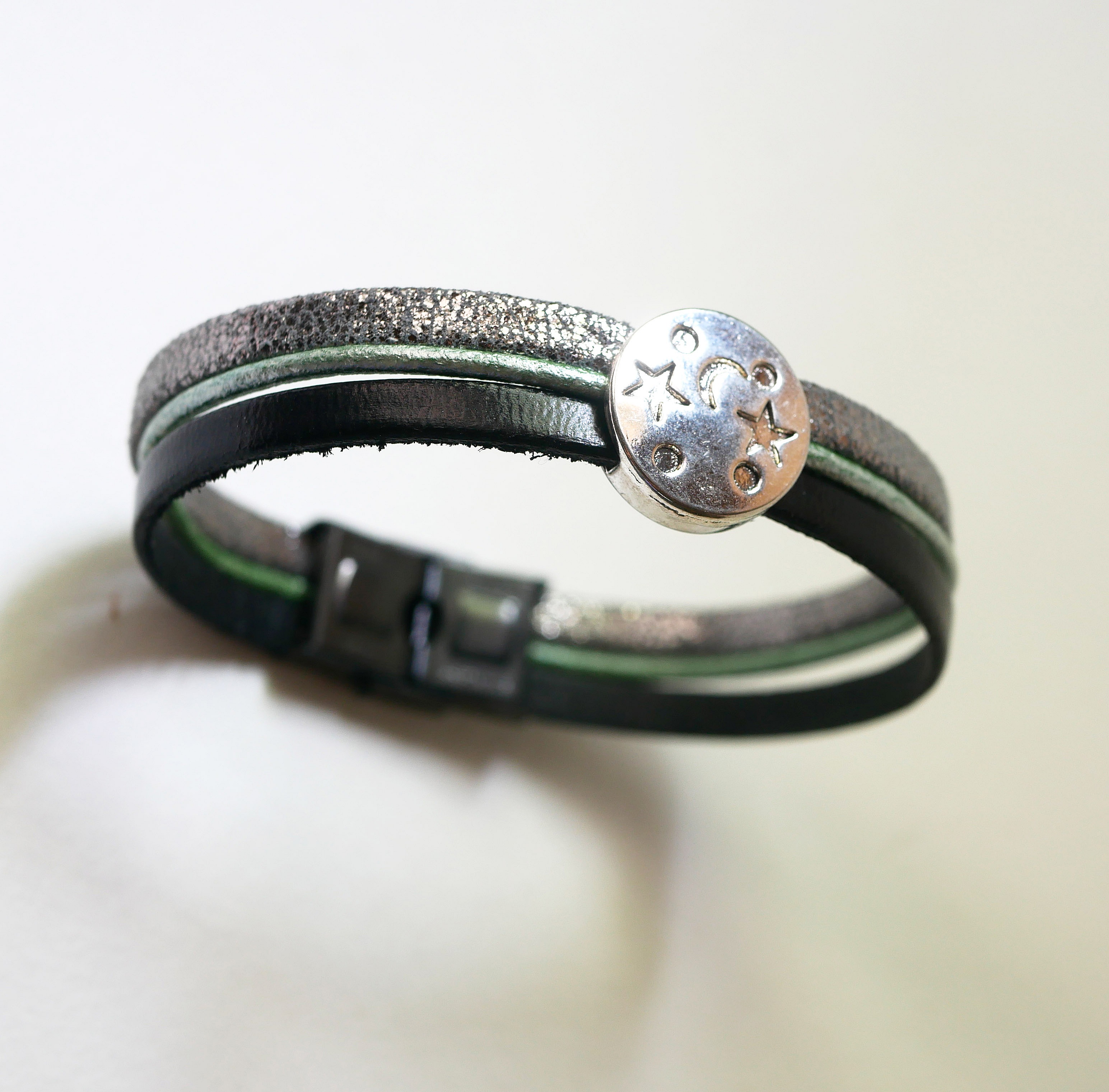 M&aring;nestjernearmb&aring;nd i skinn med flere lenker i s&oslash;lv, gr&oslash;nn og svart cabochon