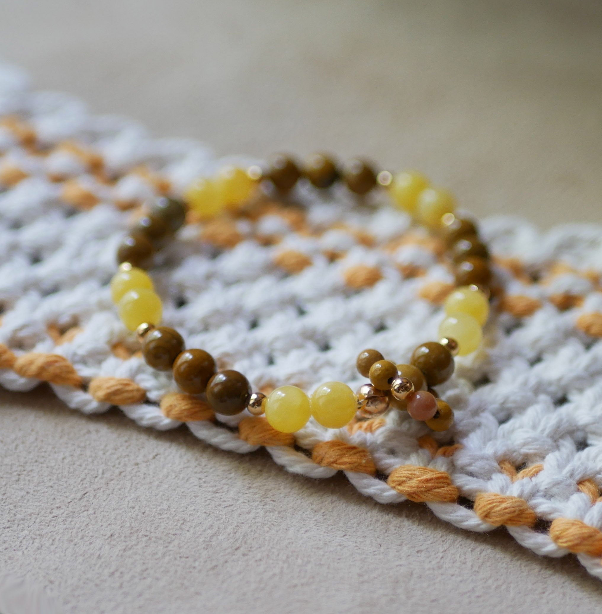 Natursteinarmbånd med gule jade- og mokaïteperler og en ring av miniperler