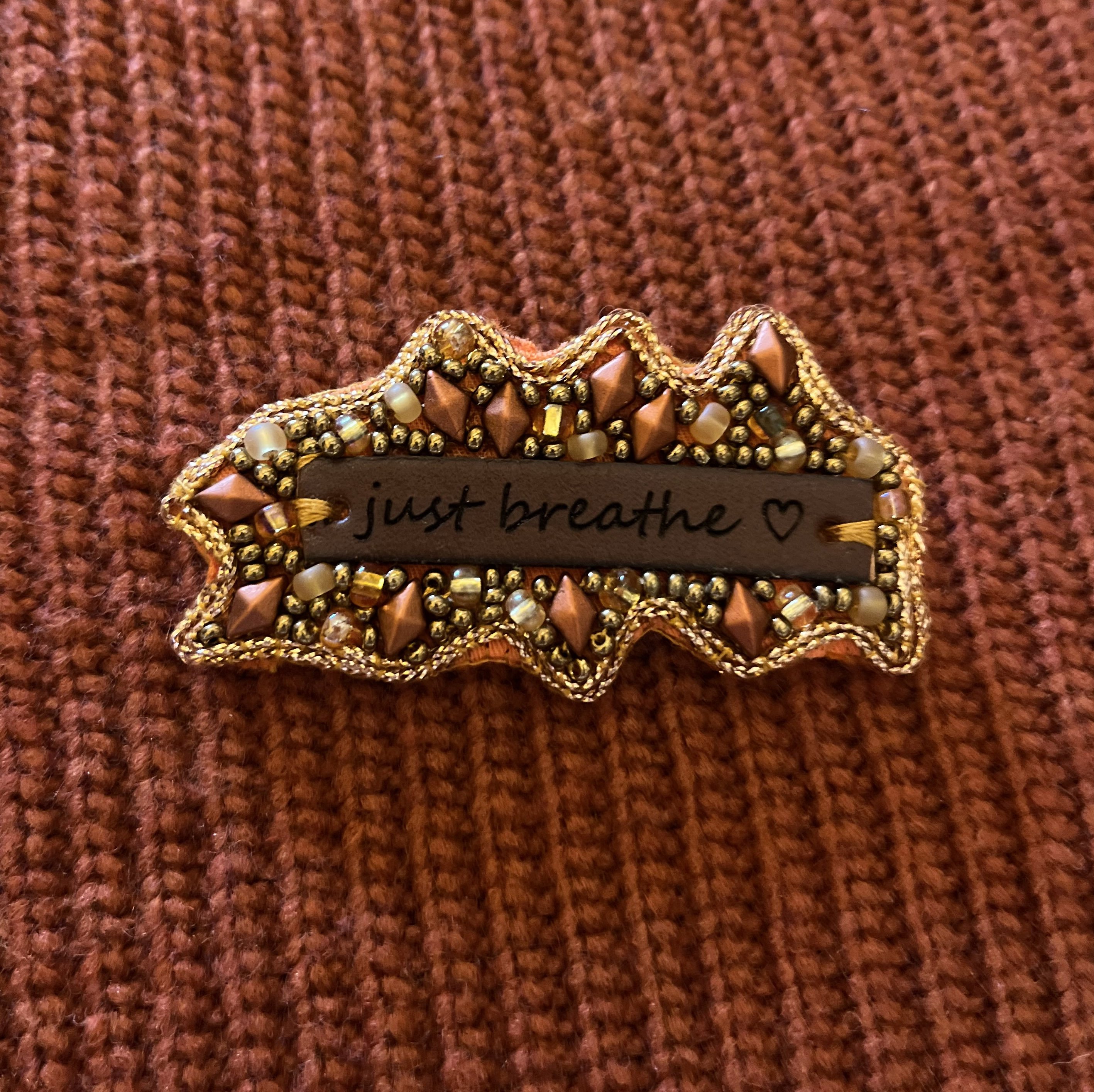 Broche en perles cuivrées à message en cuir gravé "Just breathe"