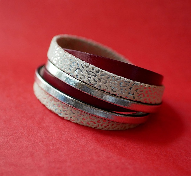 Spesialtilpasset mansjettarmb&aring;nd i hvitt, s&oslash;lv og r&oslash;dt skinn med dobbel omdreining  